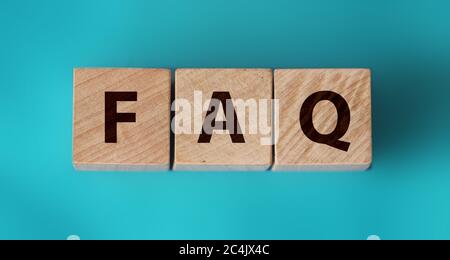 FAQ sign made of wood on an ocean blue table Stock Photo