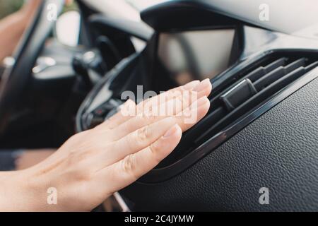 Car air conditioning. Woman checks air conditioning in a car Stock Photo