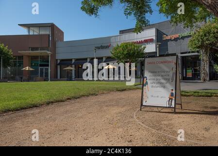 Davis, California, USA. June 20, 2020. Davis Commons is empty on a Sunday morning while a sign tells people to enjoy the outdoors while enjoying socia Stock Photo