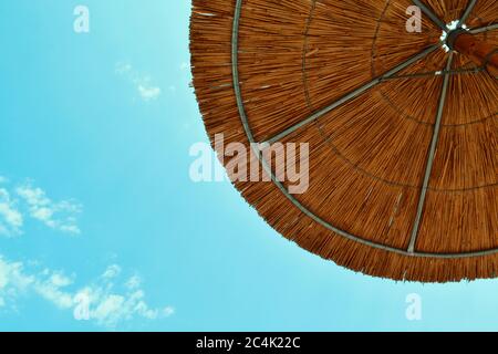 Rustic Wooden Beach Umbrella on a Clear Blue Sky Stock Photo