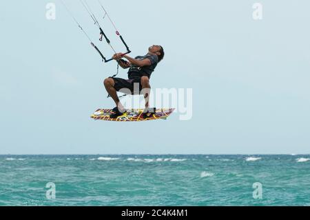 Water Sports Action. Healthy Man ( Surfer ) Kiteboarding ( Kite Surfing ) On Waves In Sea, Caribbean Ocean. Extreme Sport. Summer Fun, Playa del Carme Stock Photo