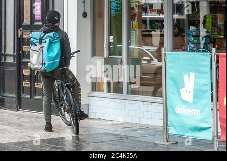 Deliveroo Food Delivery Rider waiting for an order next to a 