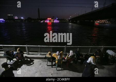 Cairo, Egypt. 27th June, 2016. People sit on the bank of river nile in front of Cairo Tower following the easing of the Coronavirus (Covid-19) lockdown restrictions. Egyptian authorities allowed the partial reopening of businesses in an attempt to mitigate the economic impact of the virus. Coffee shops and restaurants were permitted to reopen, but at 25 per cent of the usual capacity to avoid crowding. Credit: Gehad Hamdy/dpa/Alamy Live News