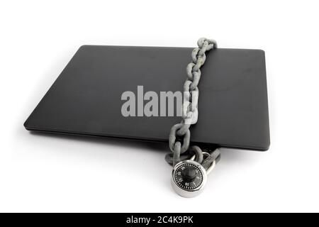 a closed notebook computer with a chain and combination lock wrapped around it isolated on white Stock Photo