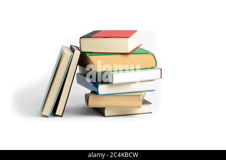 an uneven stack of old hard cover bound books isolated on white Stock Photo