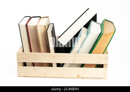 old books lined up in a wooden crate isolated on white Stock Photo