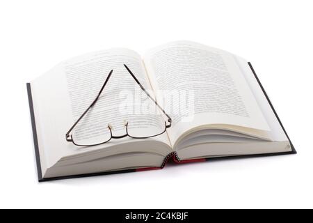 a pair of reading glasses lying on a thick hard cover book isolated on white Stock Photo