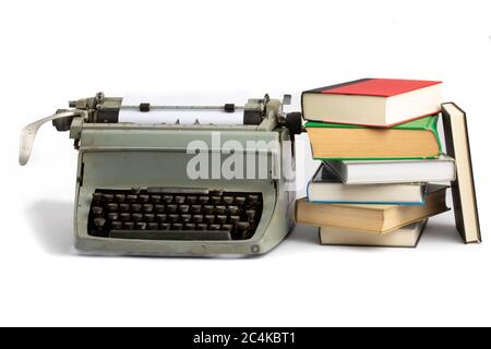 an old grungy manual typewriter with a stack of old books isolated on white Stock Photo