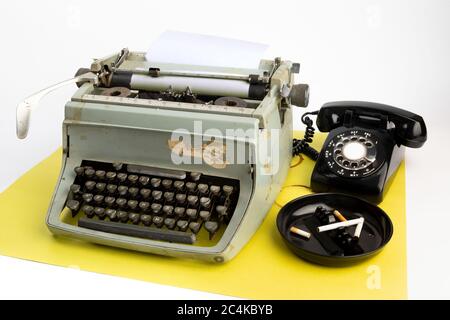 pre internet journalist's workstation, manual typewrite, rotary phone and cigarette butts in an ashtray on white Stock Photo