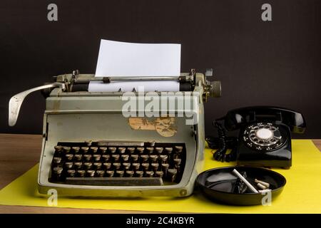 pre internet journalist's workstation, manual typewrite, rotary phone and cigarette butts in an ashtray on white Stock Photo