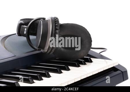 closeup of headphones lying on the keyboard of an electronic piano Stock Photo