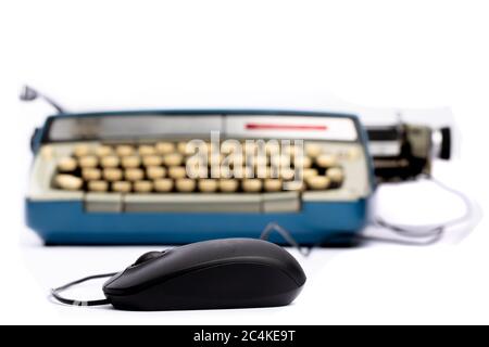 an ironic scene of a computer mouse plugged into an old manual typewriter isolated on white Stock Photo