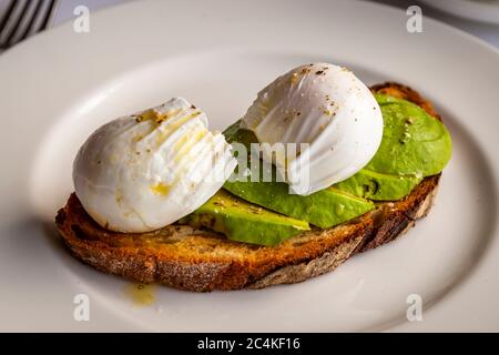Protein booster in the morning: avocado with poached egg on sourdough bread Stock Photo