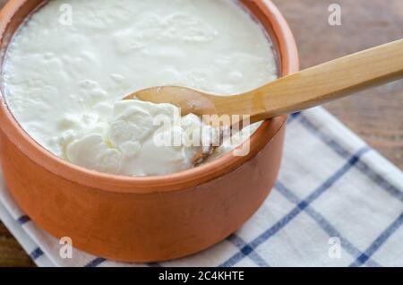 Traditional Turkish Yogurt in earthen pot on the wooden table. Stock Photo