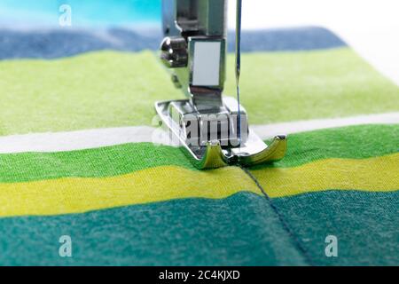 a white electric sewing machine sewing a seam on a home made covid-19 mask isolated on white Stock Photo