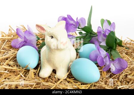 farm Easter, an Easter bunny, colorful Easter eggs and flowers on a hay bale isolated on white Stock Photo
