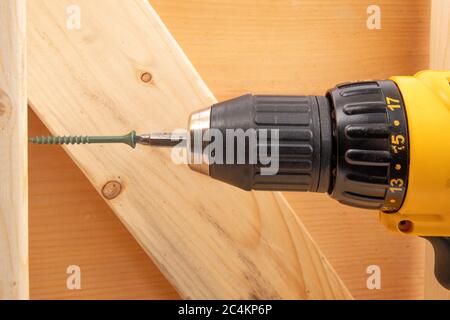 closeup of a yellow battery operated drill with screwdriver bit in a residential frame construction setting Stock Photo