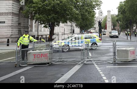 London, UK. 27th June, 2020. A police officer in Whitehall as barriers are already put in place in case of any trouble which may arise from any of the protests and rallies today in London. Credit: Paul Marriott/Alamy Live News