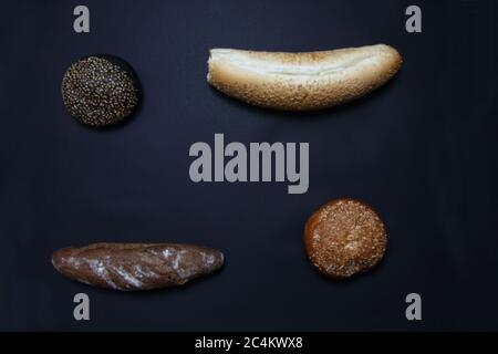two baguettes and two scones isolated on black background flat lay. Image contains copy space Stock Photo
