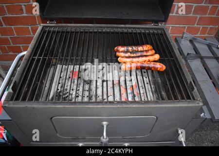 Grilled Memphis style hot dog outdoor-bred British pork sausages. UK summertime treat The smoky bbq heat of is the best way to flavour a fresh sausage Stock Photo