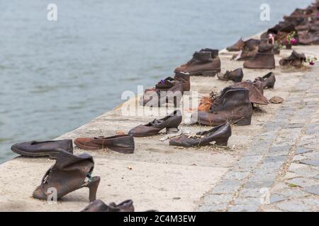 Shoes symbolizing the massacre of people shot at the river Danube during World War 2 in Budapest in Hungary in a beautiful summer day Stock Photo