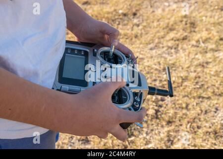 High angle shot of male pushing buttons on the remote control in the field Stock Photo
