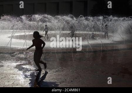 Children playing in water fountain during summer heat Stock Photo