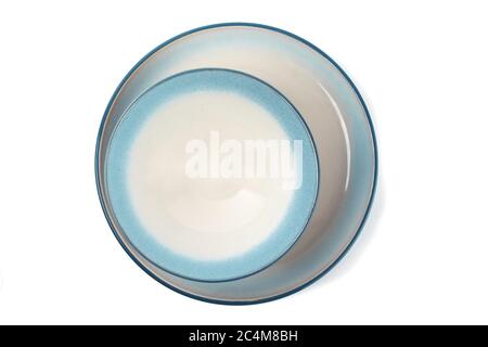 overhead view of a blue soup bowl on a blue dinner plate isolated on white Stock Photo
