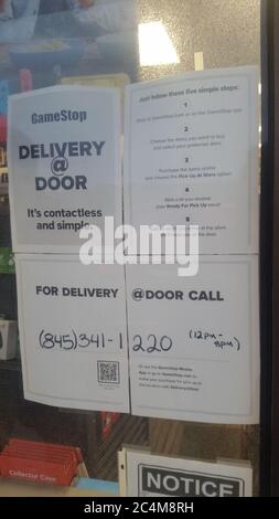 MIDDLETOWN, NY, UNITED STATES - May 29, 2020: Gamestop advertises Delivery at Door Signs in Middletown NY Store Window. Door to Door Service during CO Stock Photo