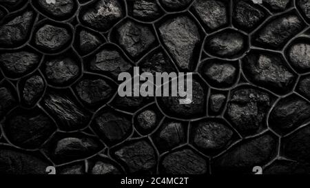Dark monochrome wall made of stone and cement. Mosaic of rocks used as tiles. Black stone fence. Decorative texture from natural material. Background Stock Photo
