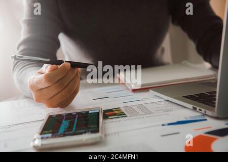 Businesswoman analyze business report graph and finance chart at corporate office. Concept of finance economy, banking business and stock market resea Stock Photo