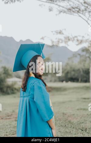 Portrait of a Filipino Woman wearing her Graduation cap, gown and Sash. Stock Photo