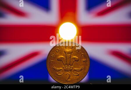 British coin 2 pence (2001) isolated on (UK) United kingdom flag background and lighting with space for copy text. Front side of two pence coin. Engla Stock Photo