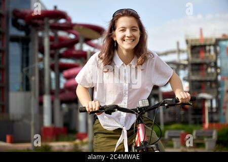Urban biking teenage girl, bike in city. Active lifestyle. Stock Photo