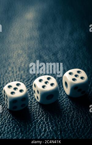 Dice with fives on a dark blue leather table. Stock Photo