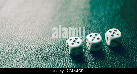 Dice with fives on a green leather table Stock Photo
