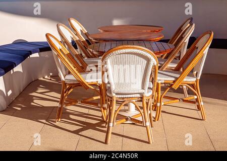 Tables and chairs set up for outdoor dining on a bright hot sunny summer day Stock Photo