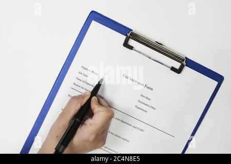 Closeup of a person signing an Exit interview form Stock Photo