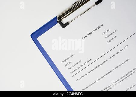 Closeup of a document entitled 'Exit interview form' on a blue clipboard Stock Photo