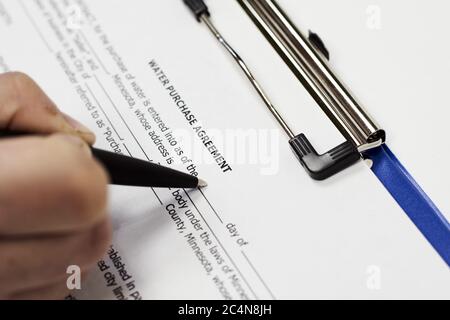 Closeup of a person signing a Water Purchase Agreement Form Stock Photo