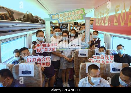Hefei. 28th June, 2020. Train attendants pose for photos with passengers aboard train No. G9394 travelling from Hefei to Hangzhou on the Shangqiu-Hefei-Hangzhou high-speed railway, June 28, 2020. A new high-speed railway route connecting east and central China started operation on Sunday. With a designed speed of 350 kph, the route connects the city of Shangqiu in central China's Henan Province, and Hefei and Hangzhou, the capital cities of east China's Anhui and Zhejiang provinces. Credit: Liu Junxi/Xinhua/Alamy Live News Stock Photo