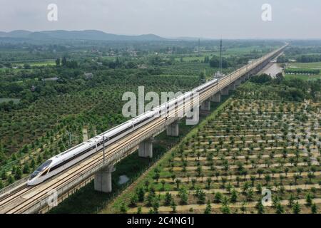 Hangzhou. 28th June, 2020. Aerial photo taken on June 28, 2020 shows a bullet train running on the Shangqiu-Hefei-Hangzhou high-speed railway in Anji County, east China's Zhejiang Province. A new high-speed railway route connecting east and central China started operation on Sunday. With a designed speed of 350 kph, the route connects the city of Shangqiu in central China's Henan Province, and Hefei and Hangzhou, the capital cities of east China's Anhui and Zhejiang provinces. Credit: Huang Zongzhi/Xinhua/Alamy Live News Stock Photo