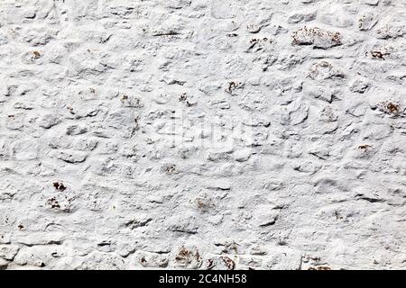 Old grey white weathered rough stone wall texture background Stock Photo