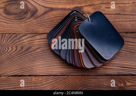 Leather samples for shoes on dark wooden table. Designer furniture clothes. Stock Photo