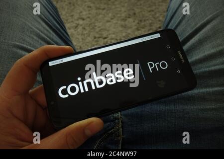 Man holding smartphone with Coinbase Pro cryptocurrency exchange logo Stock Photo