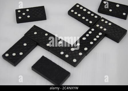 Closeup shot of black dominoes on a white surface Stock Photo