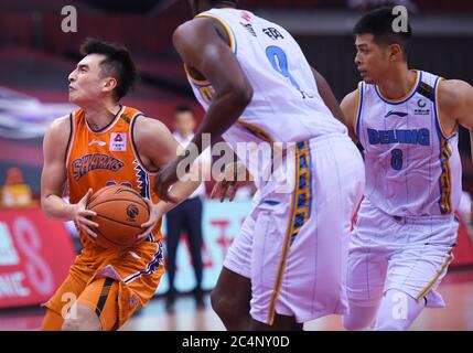 Qingdao, China's Shandong Province. 28th June, 2020. Luo Hanchen (L) of Shanghai Sharks runs with the ball during a match between Beijing Ducks and Shanghai Sharks at the newly resumed 2019-2020 Chinese Basketball Association (CBA) league in Qingdao, east China's Shandong Province, June 28, 2020. Credit: Li Ziheng/Xinhua/Alamy Live News Stock Photo