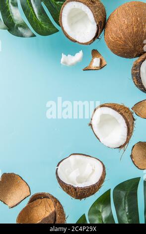 Halves of coconut, open  cut in half isolated on blue background. Coconut pulp is very healthy wholesome food. Top view, copy space, place for text. Stock Photo