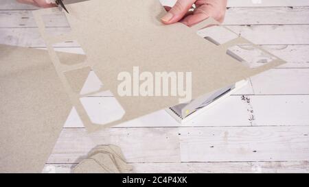 Step by step. Cutting out gift tags from brown paper with a paper punch  Stock Photo - Alamy