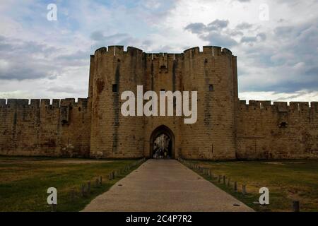 Aigues-Mortes, Camargue, Gard, Occitanie, France. Town surrounded by medieval walls, connected to the Rhone river through river channels. Porte des Moulins, one of the entrances to the old city, along the 13th century walls. Stock Photo